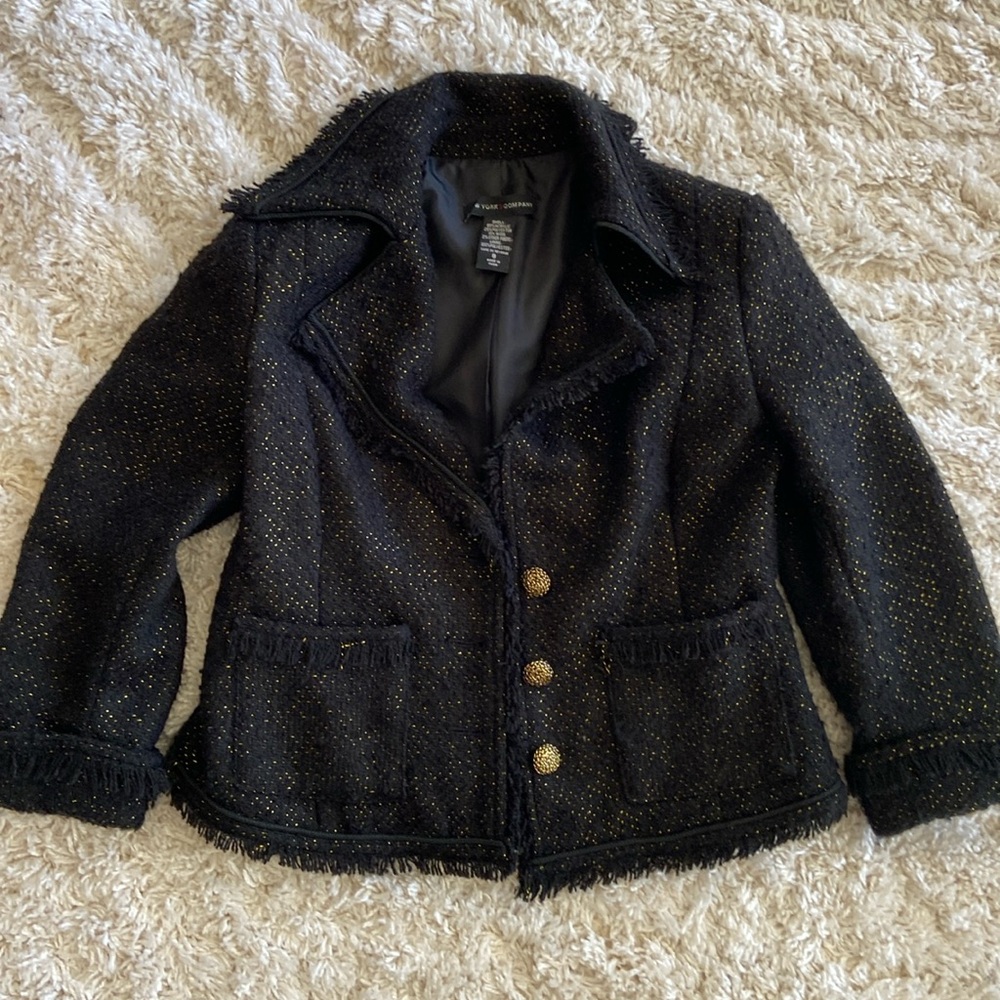 Black casual jacket with golden accents and buttons.